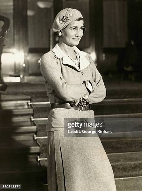 Gabrielle "Coco" Chanel in suit and beret.
