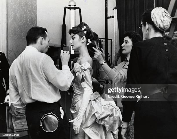 Makeup artist and hairstylists prepare Audrey Hepburn for a scene in Mayerling.