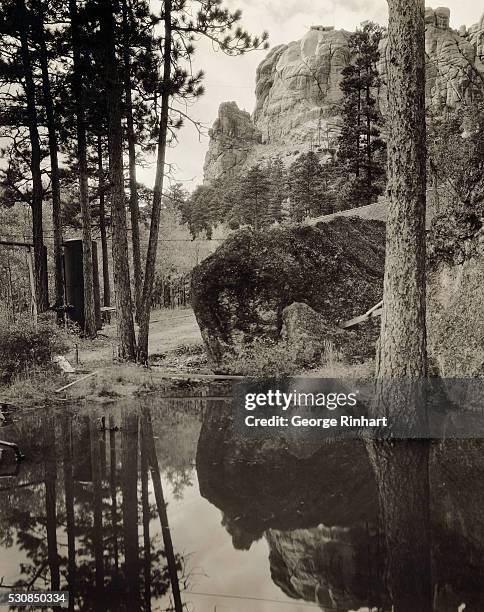 Reflections of Mount Rushmore is seen here. Washington may be seen at the top. The cylindrical tank at the left provides compressed air for the...