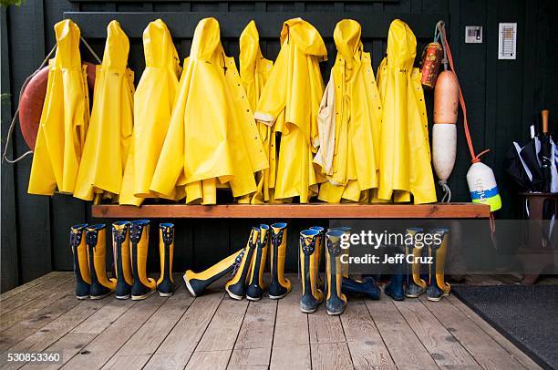 yellow raincoats and rubber boots lined up, tofino, british columbia, canada - rubber boots imagens e fotografias de stock