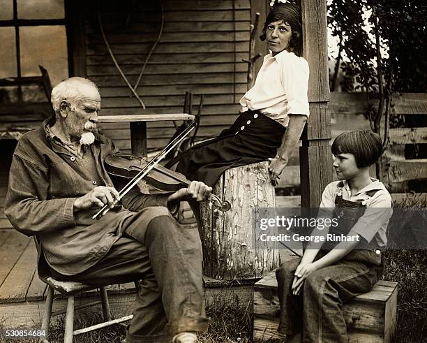 Elmer Clifford, known as the Old Man of the Adirondacks, seated outside his 115-year-old shack, playing a weird mountain tune to visitors from the...