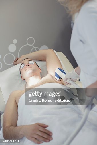Young man receiving laser treatment Young man receiving laser treatment