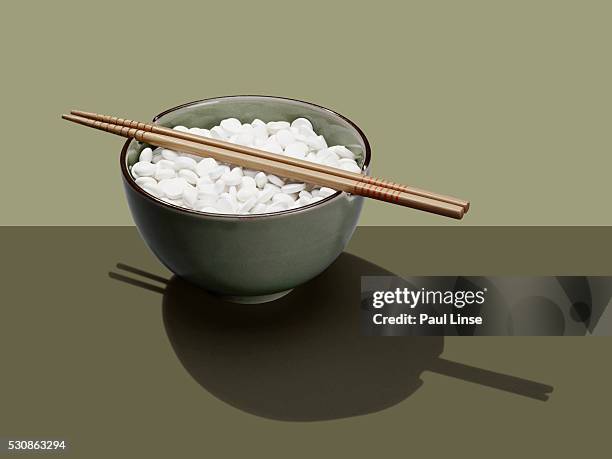 bowl of aspirin with chopsticks - paul linse stock-fotos und bilder