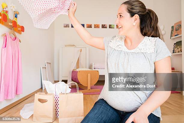 pregnant woman opening gifts at baby shower - alexandra dost stock-fotos und bilder