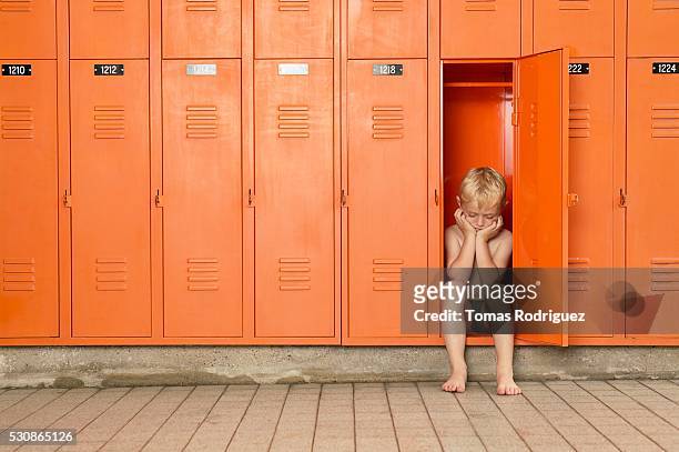 young boy pouts in locker room - vestiaires casier sport photos et images de collection