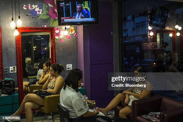 Women sit in a hair salon as a television displays the Brazilian Senate vote on the impeachment of Dilma Rousseff, Brazil's president, not pictured,...