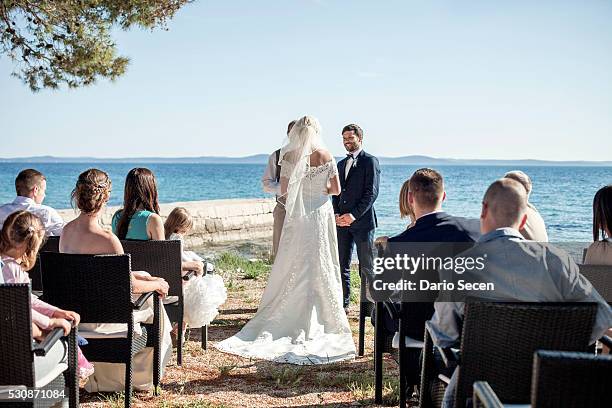 bride and groom at wedding ceremony on beach - wedding ceremony guests stock pictures, royalty-free photos & images