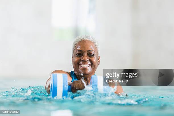 senior mujer negra hacer ejercicio, haciendo ejercicios aeróbicos en el agua - nadar fotografías e imágenes de stock
