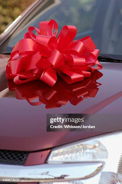 red car with red bow on it - new car bow stock pictures, royalty-free photos & images