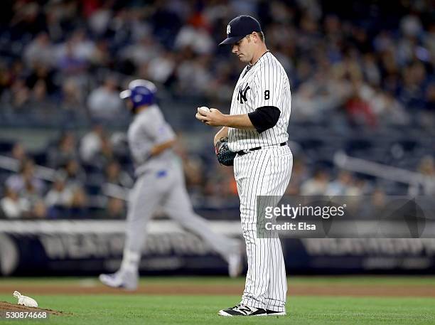 Phil Coke of the New York Yankees reacts as Kendrys Morales of the Kansas City Royals rounds third base after a solo home run in the seventh inning...