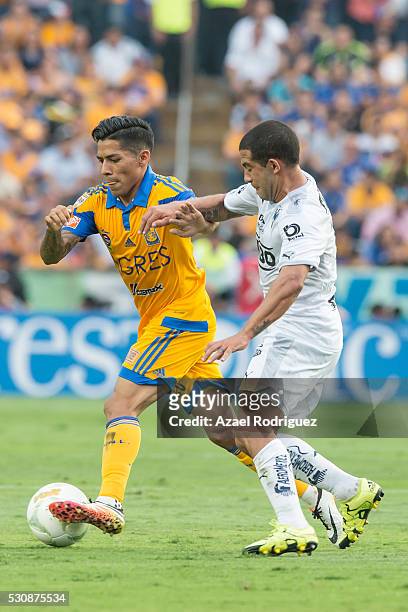 Javier Aquino of Tigres fights for the ball with Walter Gargano of Monterrey during the quarter finals first leg match between Tigres UANL and...