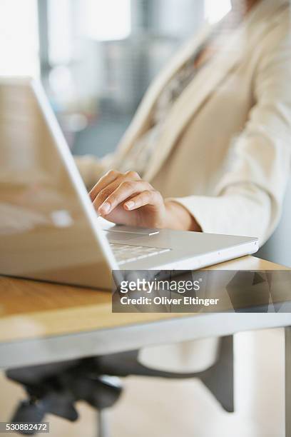 businesswoman using a laptop computer - oliver eltinger stock-fotos und bilder