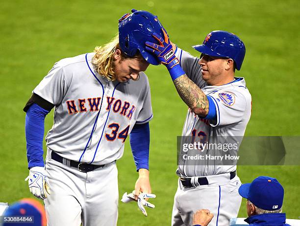 Noah Syndergaard of the New York Mets has his batting helmet removed by Asdrubal Cabrera in celebration of his solo homerun to take a 1-0 lead over...