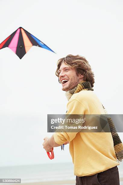 man flying a kite on the beach - kite flying stock pictures, royalty-free photos & images