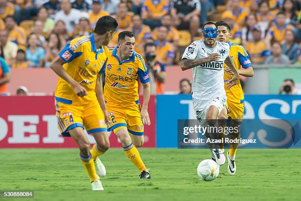 Edgar Castillo of Monterrey drives the ball while surrounded by Hugo Ayala, Israel Jimenez and Javier Aquino of Tigres during the quarter finals...