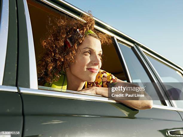 young woman looking through car window - linse photos et images de collection