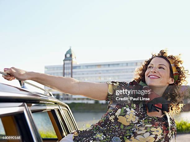 young woman looking through car window - linse photos et images de collection