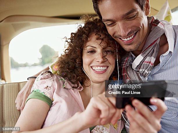 young couple sitting in car - linse photos et images de collection