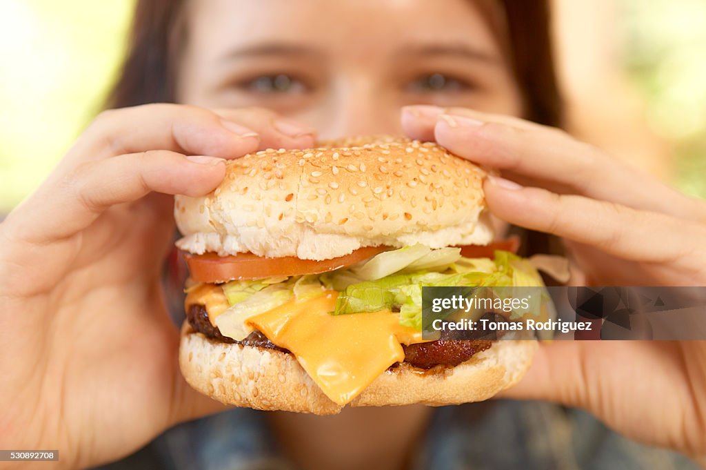 Teen girl with cheeseburger