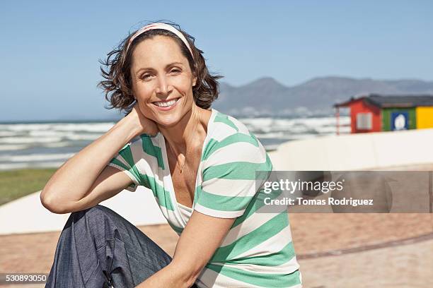 woman sitting on a beach - 40 49 years stock pictures, royalty-free photos & images