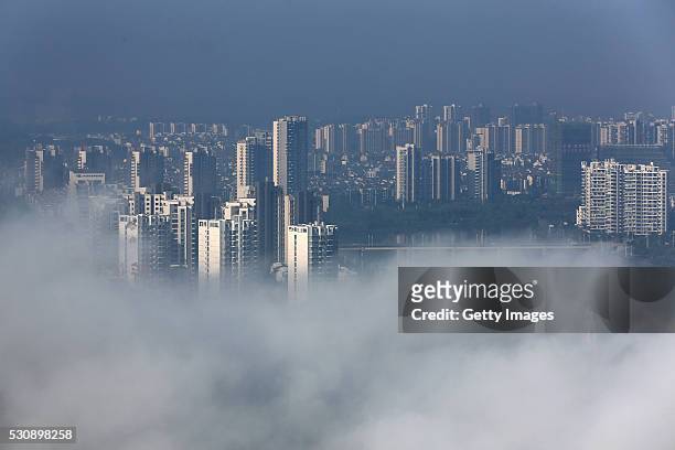 Clouds pile up above city buildings after rain on May 12, 2016 in Huangshan, Anhui Province of China.
