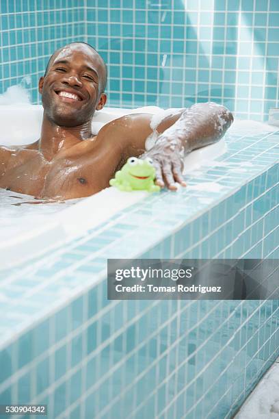 man taking a bath with bath toys - blue frog stock pictures, royalty-free photos & images