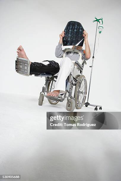 person in wheelchair holding x-rays - leg cast hospital stock pictures, royalty-free photos & images