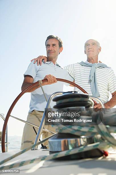 father and son on boat - father son sailing stock-fotos und bilder