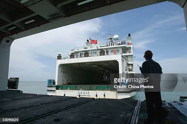 Chinese workers take part in a fire drill onboard a ferry which transports passenger trains between Guangdong Province and Hainan Island on June 16,...