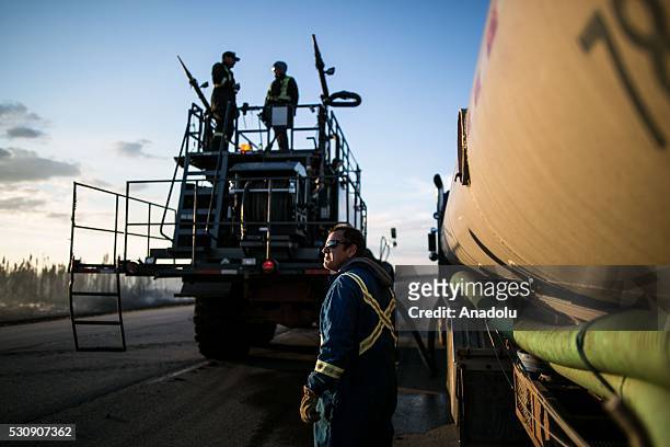Fire support crew members make preparations during a wildfire that erupted outside Fort McMurray, Alberta, Canada on May 11, 2016. Wildfire erupted...