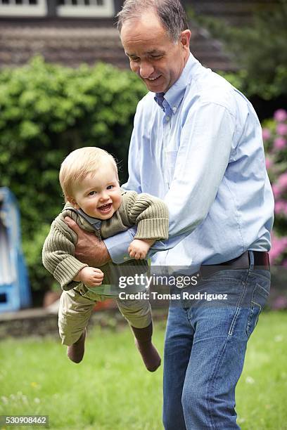 man playing with grandson - active baby boomer stock pictures, royalty-free photos & images