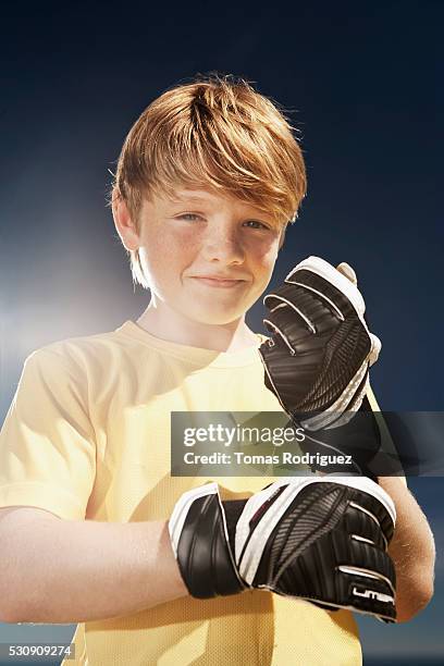 goalkeeper adjusting gloves - keepershandschoen stockfoto's en -beelden