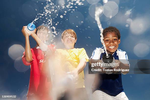 soccer players squirting each other with water bottles - water bottle splash stock pictures, royalty-free photos & images