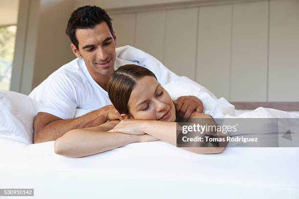 couple in bed - woman massage stock pictures, royalty-free photos & images