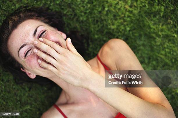 laughing woman on the grass - verlegen stockfoto's en -beelden