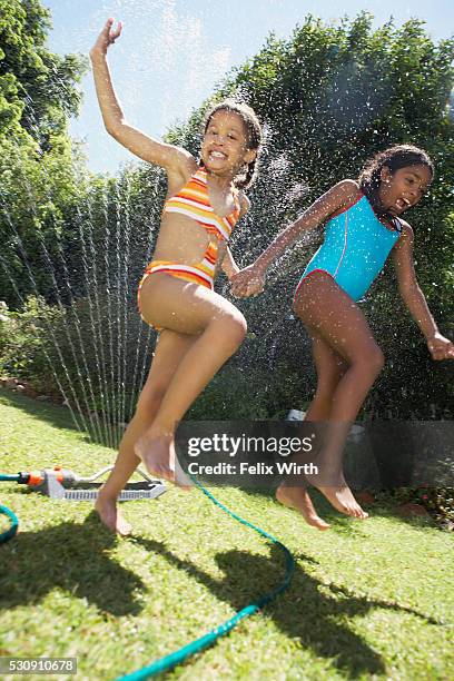 girls running through sprinklers - monokini stock pictures, royalty-free photos & images