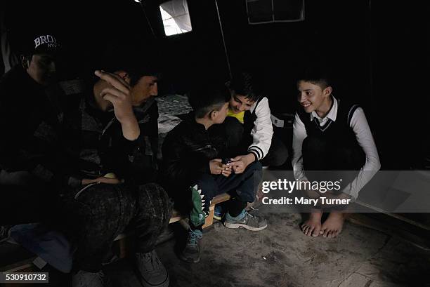 Bakht, Wali, Yasseen and Habib Khan from Laghdar and Jalalabad in Afghanistan, play on their mobile phones to help pass the long afternoons in the...