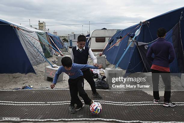 Bilal, aged 9, and his friend Habib from Jalalabad in Afghanistan, play football together to pass the time in the camp known as 'The Jungle' where...