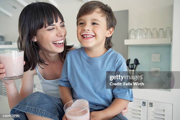 mother and son drinking smoothies - milk moustache stock-fotos und bilder