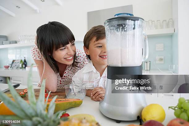 mother and son making smoothies in blender - grape smoothie ストックフォトと画像