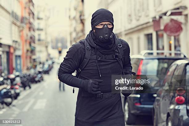 homme faire du jogging en noir dans les rues de paris avec appareils respiratoires - anti-terrorisme photos et images de collection