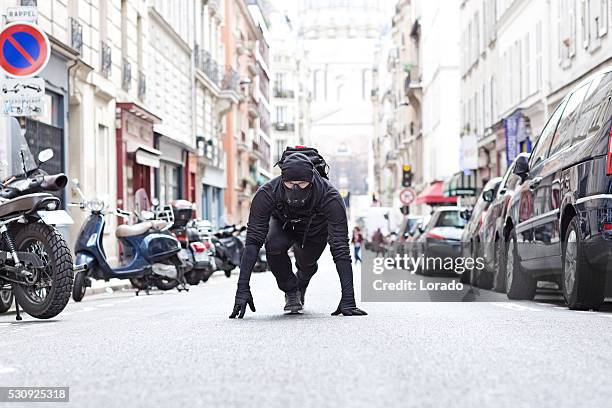 man exercising in black in paris street wearing breathing apparatus - street villains stock pictures, royalty-free photos & images