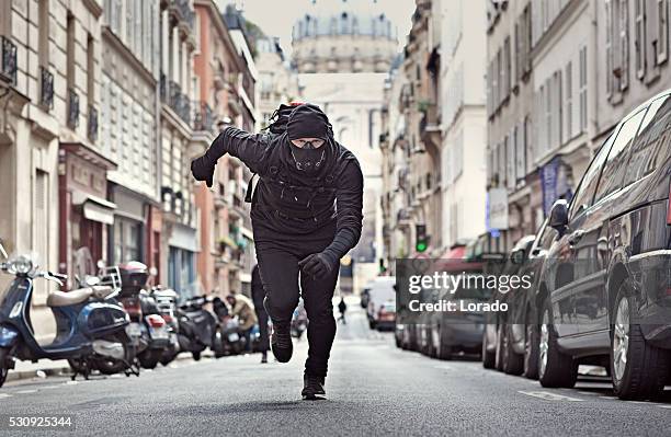 male jogging in black in paris street wearing breathing apparatus - street villains stock pictures, royalty-free photos & images