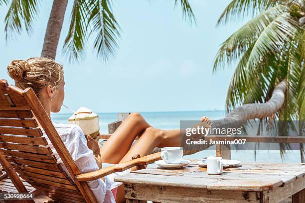 young woman enjoys drinking coffee and coconut - cafe at beach bildbanksfoton och bilder