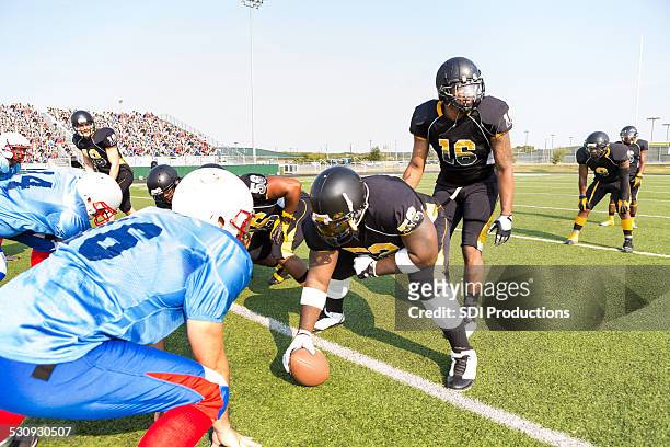 professional football teams preparing for play during game at stadium - quarterback stock pictures, royalty-free photos & images