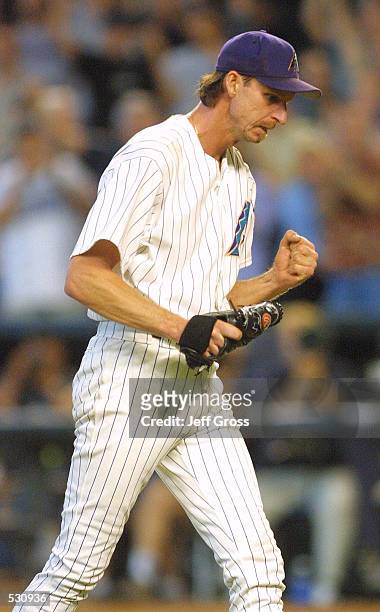 Pitcher Randy Johnson of the Arizona Diamondbacks pumps his fist after striking out Brian Jordan of the Atlanta Braves and winning game one of the...