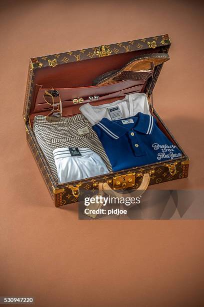 rich man's vacation suitcase on brown backdrop - louis vuitton bag stockfoto's en -beelden