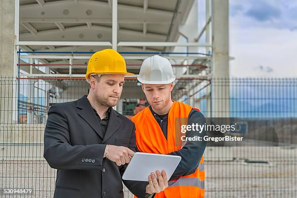 arquitecto y trabajador de construcción - foundations conversations with suits fotografías e imágenes de stock