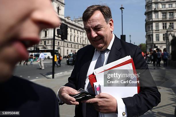 An assistant attempts to block photographs being taken of Secretary of State for Culture, Media and Sport, John Whittingdale , as he walks to...