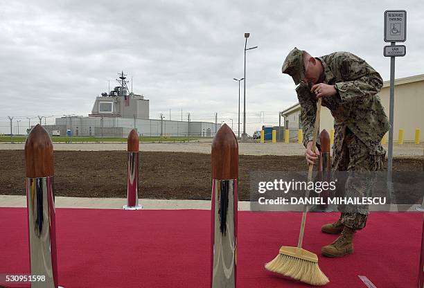 Army personnel cleans the red carpet ahead an inauguration ceremony of the US anti-missile station Aegis Ashore Romania at the military base in...